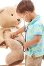 Boy child, teddy bear and stethoscope in studio for playing doctor, listening and wellness by white background. Kid Royalty Free Stock Photo