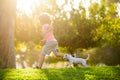 Boy child walk with puppy. Kid with pets running. Happy Child and dog runs at backyard lawn. Royalty Free Stock Photo