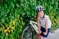 Boy child in white bicycle helmet inflating tire Royalty Free Stock Photo