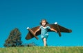 Boy child with wings at sky imagines a pilot and dreams of flying. Kids adventure, children freedom and imagination Royalty Free Stock Photo