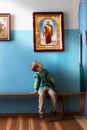 A boy in the church looks at the icons Royalty Free Stock Photo