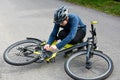 Boy squatting on the floor and checks his bike