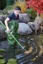 Boy cleaning garden pond Royalty Free Stock Photo