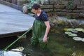 Boy cleaning garden pond Royalty Free Stock Photo