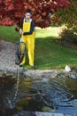 Boy cleaning garden pond Royalty Free Stock Photo