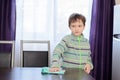 Boy cleaning table in kitchen