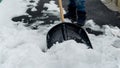 Boy clearing the backyard or walkway from snow after a snowstorm or blizzard. Concept of winter, snow removal, and hard work