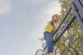 The boy climbed onto the fence. The child climbs on the gate, fe Royalty Free Stock Photo