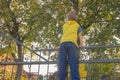 The boy climbed onto the fence. The child climbs on the gate, fe Royalty Free Stock Photo