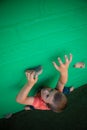 Boy climbing on green wall Royalty Free Stock Photo