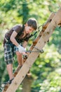 Boy climbing ladder with equipment in adventure rope park Royalty Free Stock Photo