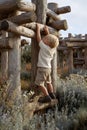 Boy climbing on log structure in natural setting Royalty Free Stock Photo