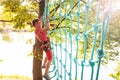 Boy climbing net high on tree at adventure park Royalty Free Stock Photo