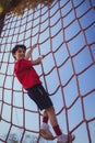 Boy climbing a net during obstacle course training Royalty Free Stock Photo