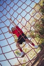 Boy climbing a net during obstacle course training Royalty Free Stock Photo