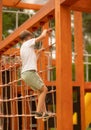 boy climbing on a rope ladder in a children's playground Royalty Free Stock Photo