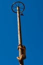 Boy climbing up on wooden slippery column to take the red woman boots