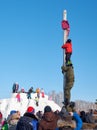 Boy climbing on a wooden pole for the prize, Slavonic folk festivities Shrovetide or Maslenitsa