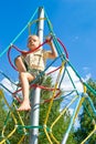 The boy climbs the ropes