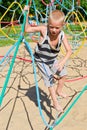 The boy climbs the ropes