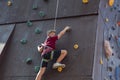 A boy climbs the top of a climbing wall in a sports park climbing wall Royalty Free Stock Photo