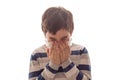 A boy with closed eyes sneezes or coughs in his hands on white background Royalty Free Stock Photo