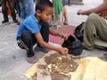 A boy collects coins for tourists to throw into a fountain at Swayambhunath Temple, the monkey temple. Kathmandu, Nepal
