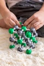 The boy collects from the constructor a model of the molecule of sodium chloride, salt according to the formula. Layout Royalty Free Stock Photo