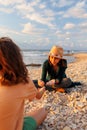 boy collects shells and pebbles in the sea on a sandy beach with his mother. Family having fun on the beach collecting shells Royalty Free Stock Photo