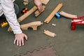 The boy collects a wooden constructor. Toy railway with a train made of wood. Educational toys