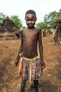 TOPOSA TRIBE, SOUTH SUDAN - MARCH 12, 2020: Boy in colorful skirt looking at camera while living in Toposa Tribe village