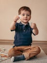 Boy connects puzzles, sitting on the floor. Educational games for children concept