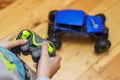 The boy is controling the blue toy car with a remote control. Child play with a toy car Royalty Free Stock Photo