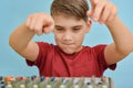 The boy controls the equalizer on the mixing console in the music studio Royalty Free Stock Photo