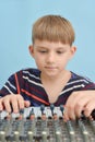 A boy controls a mixing console in a music studio Royalty Free Stock Photo