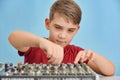 A boy controls a mixing console in a music studio Royalty Free Stock Photo