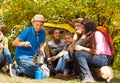 Boy cooking soup in pot for friends at campsite Royalty Free Stock Photo