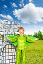 Boy in costume of green dragon near drawn tower