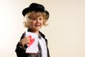 Boy in costume, showing a drawing of a heart