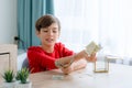 A boy counting money to put in saving box, saving money concept Royalty Free Stock Photo