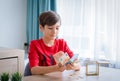 A boy counting money to put in saving box, saving money concept Royalty Free Stock Photo