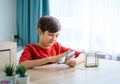 A boy counting money to put in saving box, saving money concept Royalty Free Stock Photo