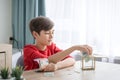 A boy counting money to put in saving box, saving money concept Royalty Free Stock Photo