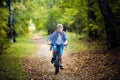 Boy in countryside riding bike in summer park smiling at camera Royalty Free Stock Photo