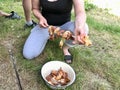 a woman impales meat on a skewer for preparing shashlik