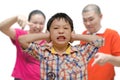 Boy covering ears while parents scold him