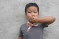 Boy covering his mouth - Asian boy covering his mouth with his hand, doesn Royalty Free Stock Photo