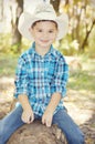 Boy with Cowboy Hat on Tree Trunk Royalty Free Stock Photo