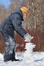 Boy creates pyramid from ice in day in winter