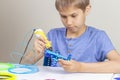 Young boy creating with 3d printing pen new object